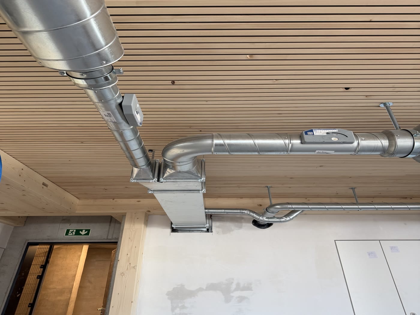 Runde Lüftungskanäle vor der Holzverkleidung, fertig montiert