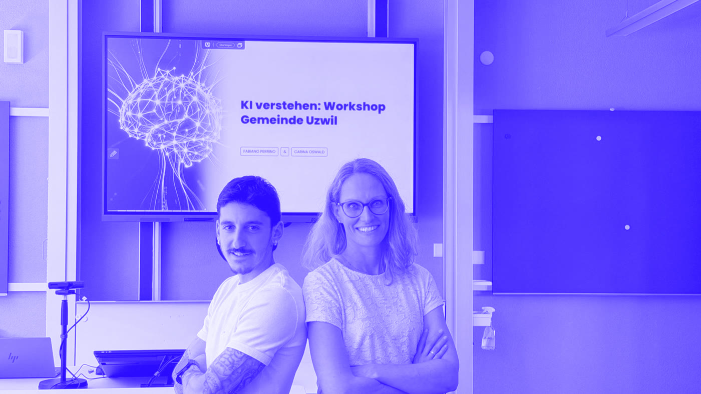 Fabiano Perrino und Carina Oswald vor der Leinwand mit dem Titel „KI verstehen: Workshop Gemeinde Uzwil“