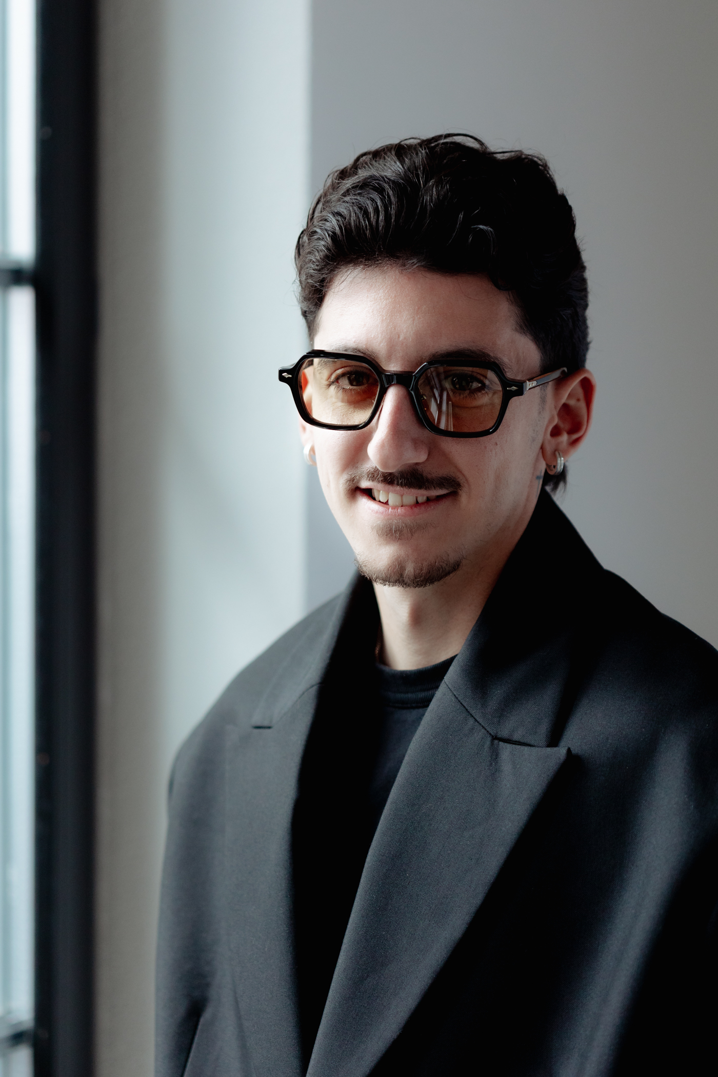 Fabiano Perrino mit Brille, lacht und schaut leicht schräge in die Kamera