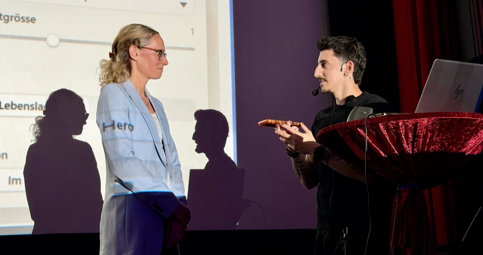 Fabiano & Carina auf der Bühne beim Vortragen eines KI-Workflow